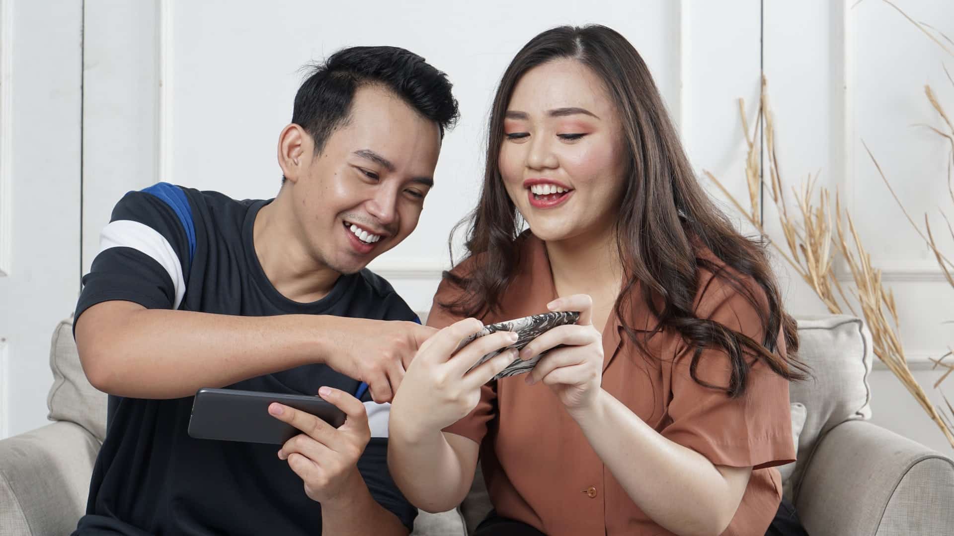 man and woman watching a video on their smartphones