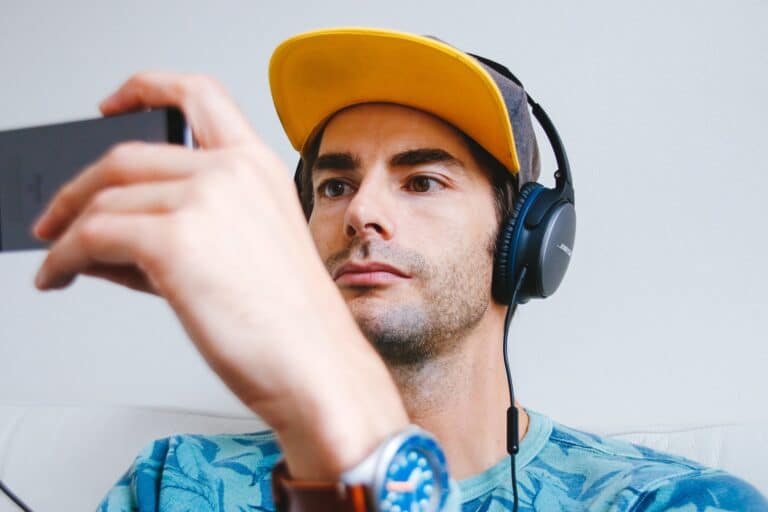 person wearing headphones and watching a video on smartphone